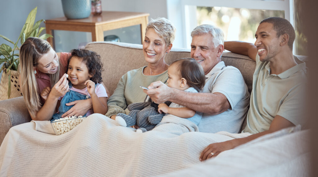 Family, children and watching a personalized mother's day gift tv grandparents, parents and kids together on a sofa in the living room.
