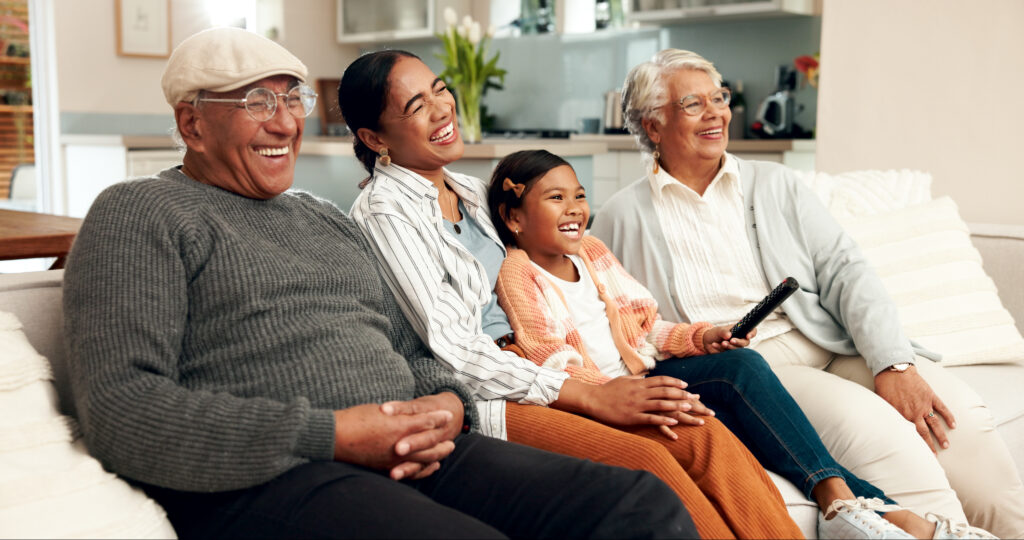 Family, laugh and couch in living room, movie and streaming with grandparents in home watching a VHS transferred tape. Lounge, remote. 